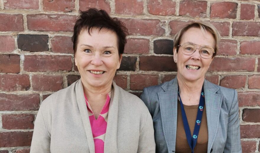 Helena ja Kirsi-Marja tiiliseinän edessä.