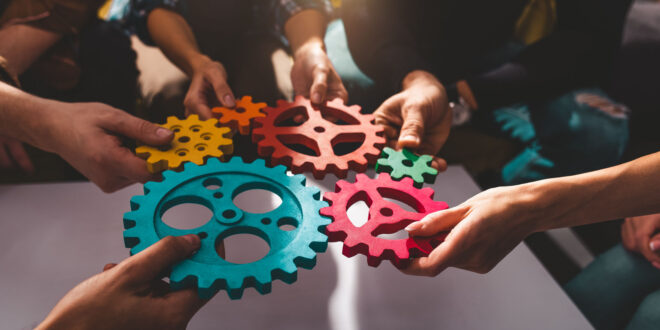 Henkilöitä pitämässä puisia ratas-elementtejä yhdessä.